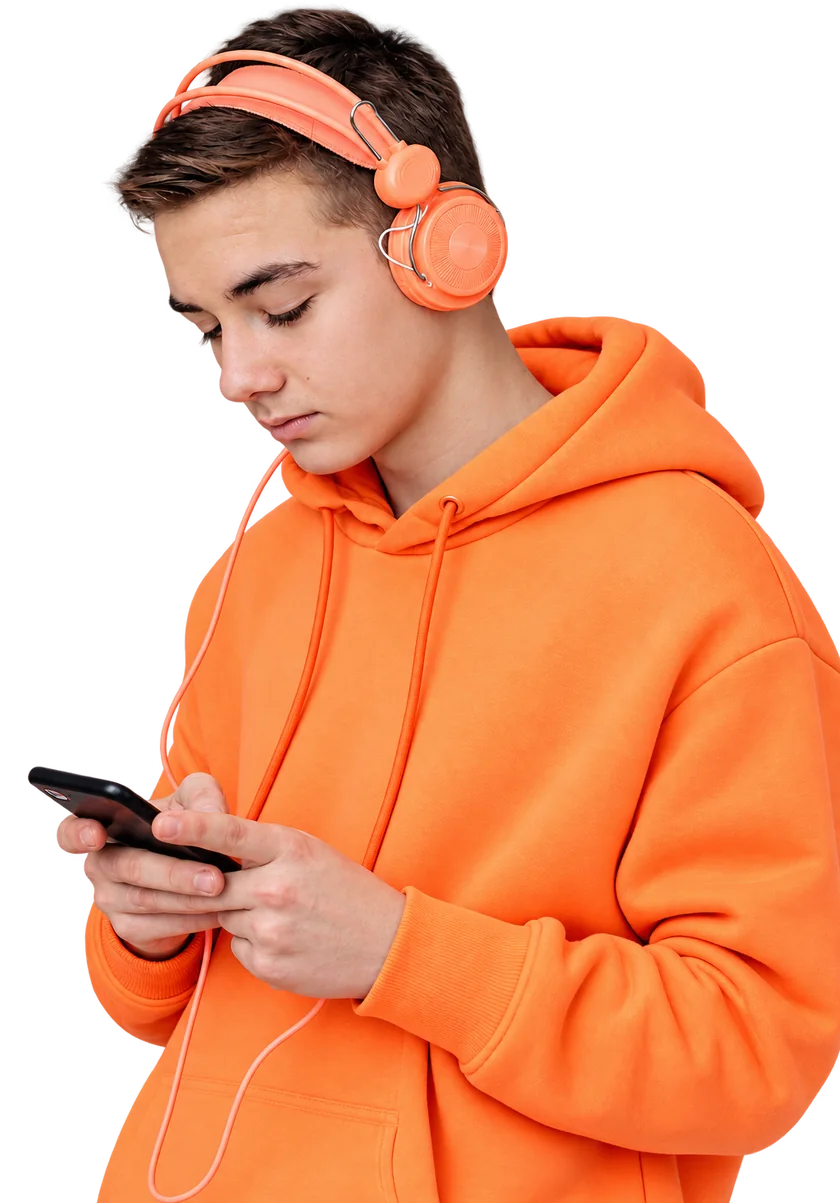 A young man in an orange hoodie and coral headphones working on his phone.
