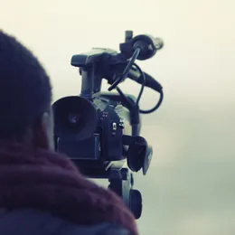 A videographer shooting with a camera on a rig.